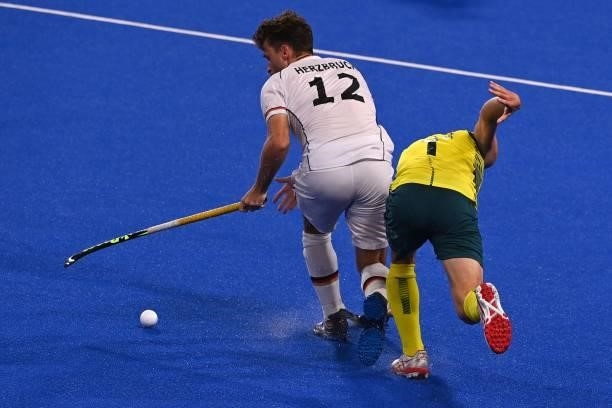 Germany's Timm Alexander Herzbruch and Australia's Lachlan Thomas Sharp vie for the ball during their men's semi-final match of the Tokyo 2020...