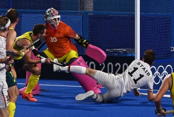 Germany's Constantin Staib falls next to Australia's goalkeeper Andrew Lewis Charter during their men's semi-final match of the Tokyo 2020 Olympic...
