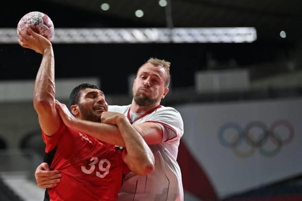 Egypt's left back Yehia Elderaa is challenged by Germany's left back Julius Kuhn during the men's quarterfinal handball match between Germany and...