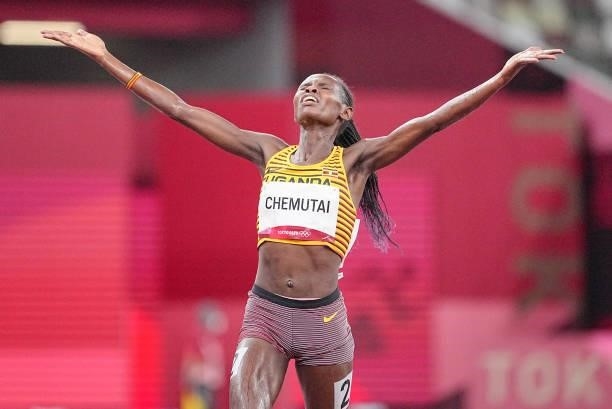 August 2021, Japan, Tokio: Athletics: Olympics, 3000m steeplechase, women, at the Olympic Stadium. Peruth Chemutai from Uganda cheers at the finish....