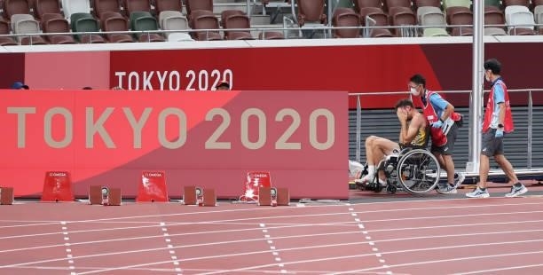 August 2021, Japan, Tokio: Athletics: Olympics, 400m decathlon, men, at the Olympic Stadium. Niklas Kaul from Germany is sitting injured in a...