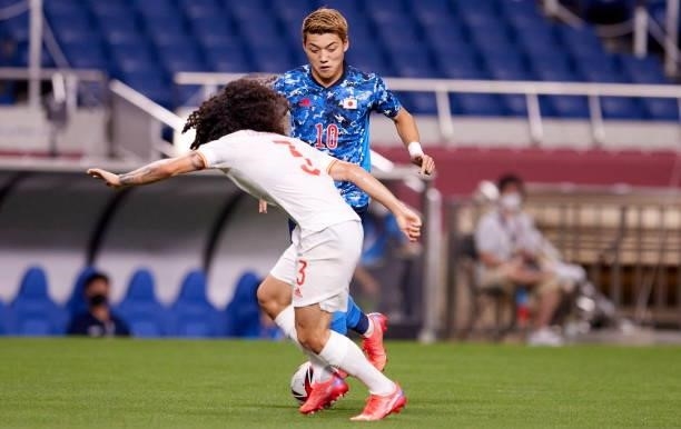 Ritsu Doan of Japan and Marc Cucurella of Spain battle for the ball during the Men's Football Semi-final Match between Japan and Spain at Saitama...