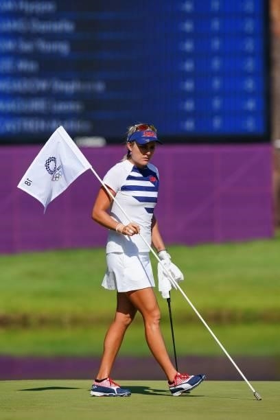 S Lexi Thompson holds the flag on the 18th green in round 2 of the womens golf individual stroke play during the Tokyo 2020 Olympic Games at the...