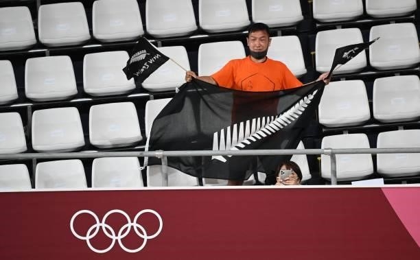 New Zealand fan holds flags during the medal ceremony of the men's track cycling omnium event during the Tokyo 2020 Olympic Games at Izu Velodrome in...