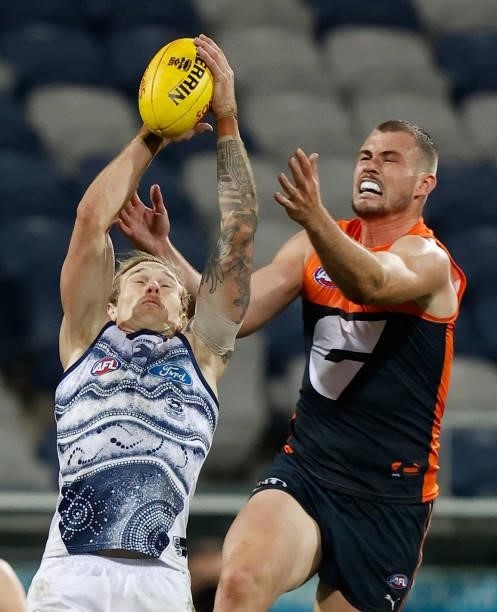 Tom Stewart of the Cats and Kieren Briggs of the Giants compete for the ball during the 2021 AFL Round 21 match between the Geelong Cats and the GWS...