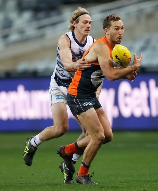 Matt Buntine of the Giants and Tom Stewart of the Cats compete for the ball during the 2021 AFL Round 21 match between the Geelong Cats and the GWS...
