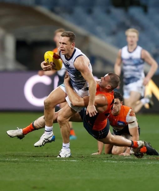 Joel Selwood of the Cats is tackled by Kieren Briggs of the Giants during the 2021 AFL Round 21 match between the Geelong Cats and the GWS Giants at...