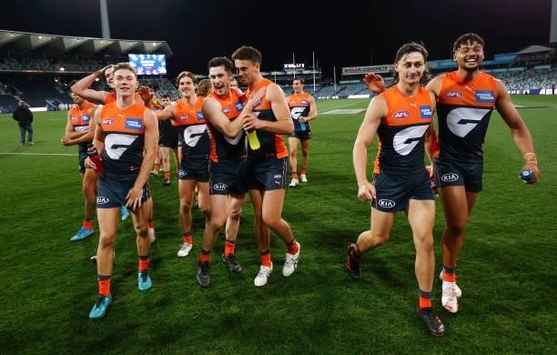 Giants players celebrate during the 2021 AFL Round 21 match between the Geelong Cats and the GWS Giants at GMHBA Stadium on August 6, 2021 in...