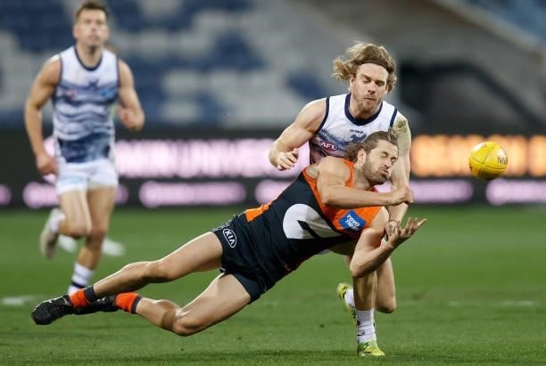 Callan Ward of the Giants is tackled by Cameron Guthrie of the Cats during the 2021 AFL Round 21 match between the Geelong Cats and the GWS Giants at...