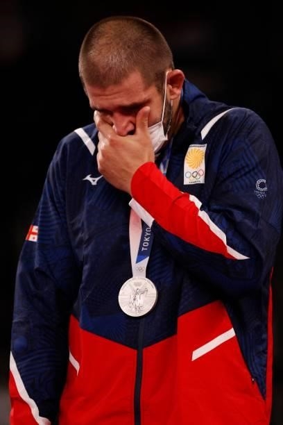 Silver medalist Iran's Georgia's Geno Petriashvili reacts on the podium after the men's freestyle 125kg wrestling competition during the Tokyo 2020...