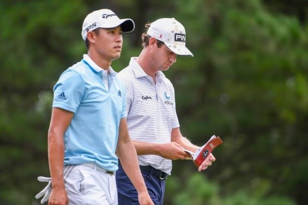 Harris English looks over his yardage book while walking with Collin Morikawa during the second round of the World Golf Championships-FedEx St. Jude...