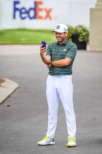 Sergio Garcia of Spain smiles while making a phone call following the second round of the World Golf Championships-FedEx St. Jude Invitational at TPC...