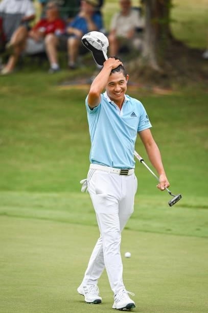 Collin Morikawa reacts and smiles after barely making a bogey putt on the ninth hole green during the second round of the World Golf...