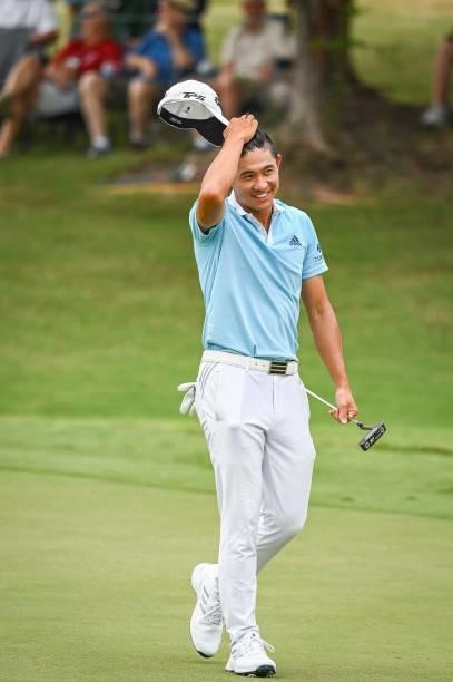 Collin Morikawa reacts and smiles after barely making a bogey putt on the ninth hole green during the second round of the World Golf...