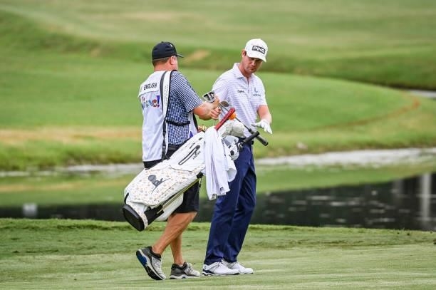 Harris English takes his putter from his caddie, who carries his bag on the ninth hole during the second round of the World Golf Championships-FedEx...