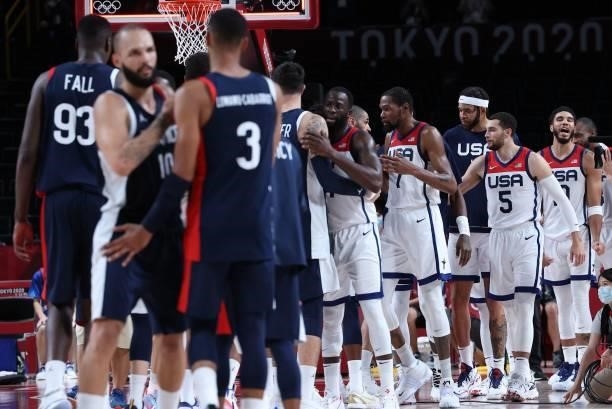 S players celebrate their win as French players react after the men's final basketball match between France and USA during the Tokyo 2020 Olympic...