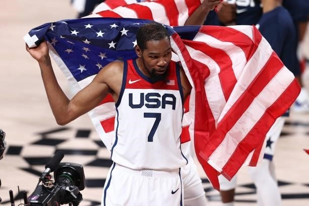 Kevin Durant of the USA Men's National Team holds a flag after the game against the France Men's National Team during the Gold Medal Game of the 2020...