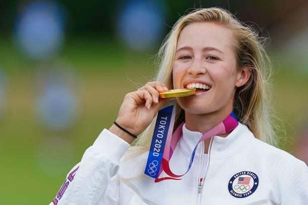 Gold medallist USA's Nelly Korda bites her medal on the podium during the victory ceremony of the womens golf individual stroke play during the Tokyo...
