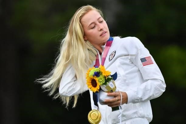 Gold medallist USA's Nelly Korda puts on her medal on the podium during the victory ceremony of the womens golf individual stroke play during the...