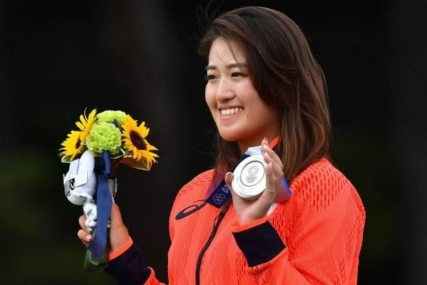 Silver medallist Japan's Mone Inami holds her medal on the podium during the victory ceremony of the womens golf individual stroke play during the...