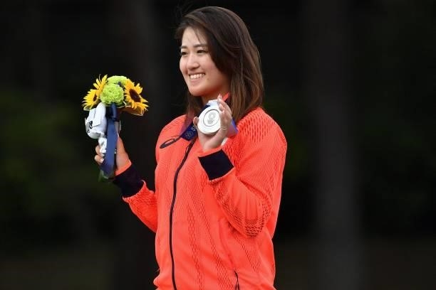 Silver medallist Japan's Mone Inami holds her medal on the podium during the victory ceremony of the womens golf individual stroke play during the...