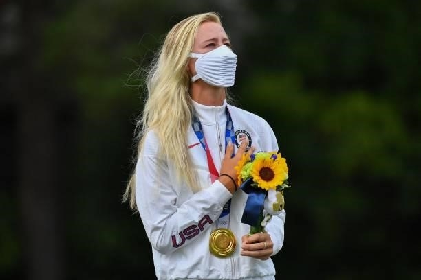 Gold medallist USA's Nelly Korda stands on the podium while singing the national anthem during the victory ceremony of the womens golf individual...