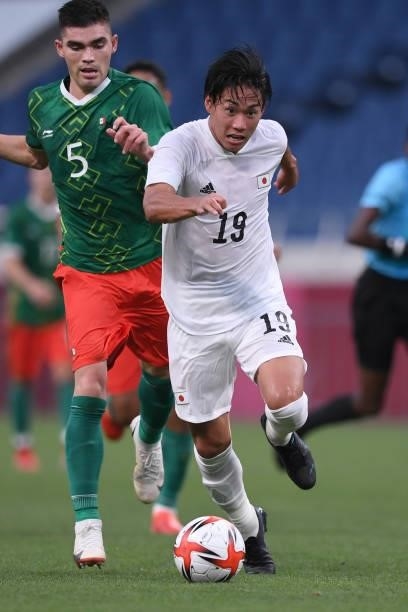 Daichi Hayashi of Japan dribbles the ball under the pressure from Johan Vasquez of Mexico during the 3rd place match of the Men's Football between...