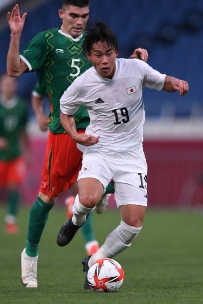 Daichi Hayashi of Japan dribbles the ball under the pressure from Johan Vasquez of Mexico during the 3rd place match of the Men's Football between...