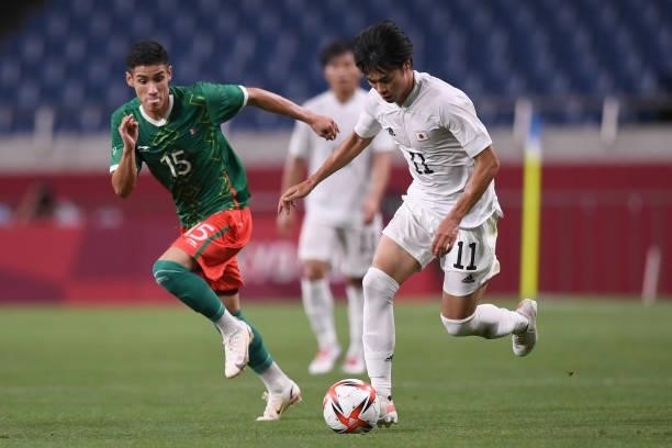 Kaoru Mitoma of Japan dribbles the ball under the pressure from Joaquin Esquivel of Mexico during the 3rd place match of the Men's Football between...