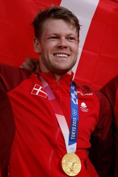 Gold medallists Denmark's Lasse Norman Hansen celebrates on podium during the medals ceremony for the men's track cycling madison during the Tokyo...