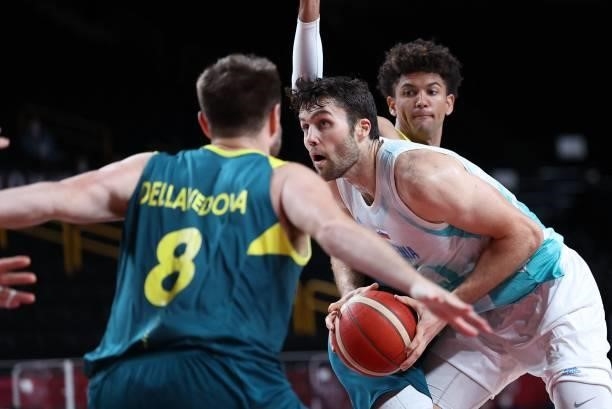 Slovenia's Mike Tobey holds the ball past Australia's Matthew Dellavedova in the men's bronze medal basketball match between Slovenia and Australia...