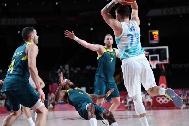 Slovenia's Luka Doncic passes the ball past Australia's Chris Goulding as Patty Mills reacts in the men's bronze medal basketball match between...