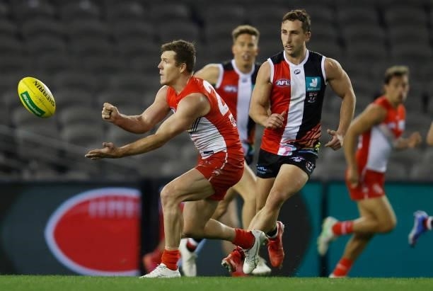 Luke Parker of the Swans handpasses the ball ahead of Luke Dunstan of the Saints during the 2021 AFL Round 21 match between the St Kilda Saints and...