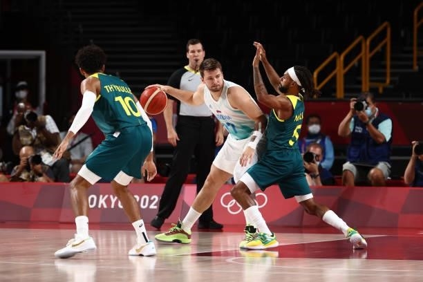 Patty Mills of the Australia Men's National Team plays defense on Luka Doncic of the Slovenia Men's National Team during the Bronze Medal Game of the...