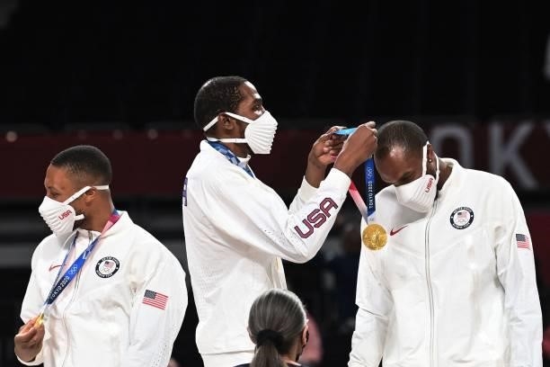 S Kevin Wayne Durant puts on a gold medal on teammate Khris Middleton during the medal ceremony for the men's basketball competition of the Tokyo...