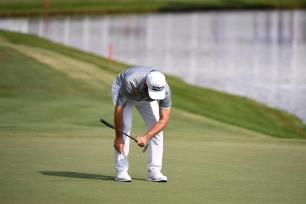 Louis Oosthuizen of South Africa drops his putter after missing his birdie putt at the 18th hole during the third round of the World Golf...