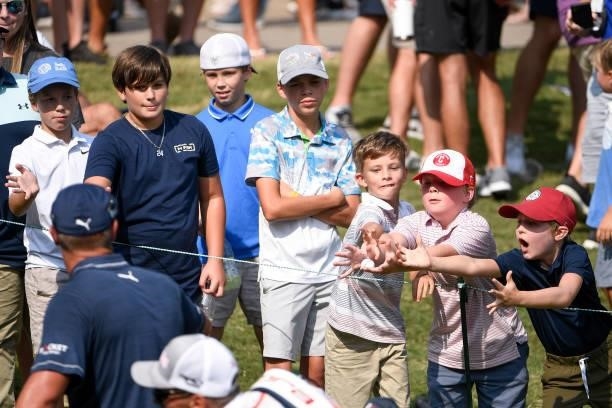 Group of young fans try to catch Bryson DeChambeaus golf ball at the 18th hole during the third round of the World Golf Championships-FedEx St. Jude...