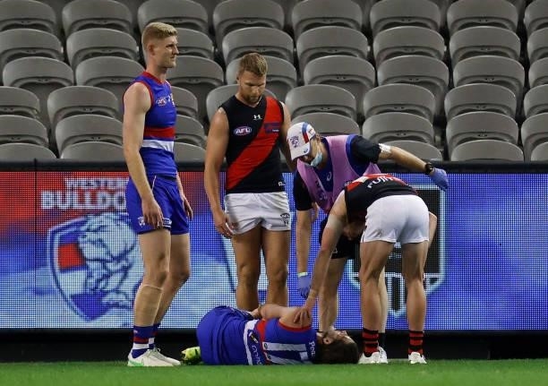 Josh Bruce of the Bulldogs lays injured after the 2021 AFL Round 21 match between the Western Bulldogs and the Essendon Bombers at Marvel Stadium on...