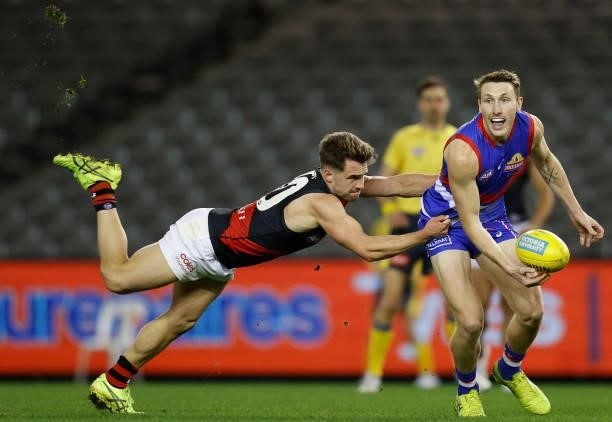 Bailey Dale of the Bulldogs is tackled by Will Snelling of the Bombers during the 2021 AFL Round 21 match between the Western Bulldogs and the...