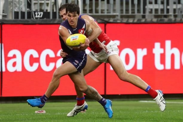 Lachie Schultz of the Docker controls the ball under pressure from Brandon Starcevich of the Lions during the 2021 AFL Round 21 match between the...