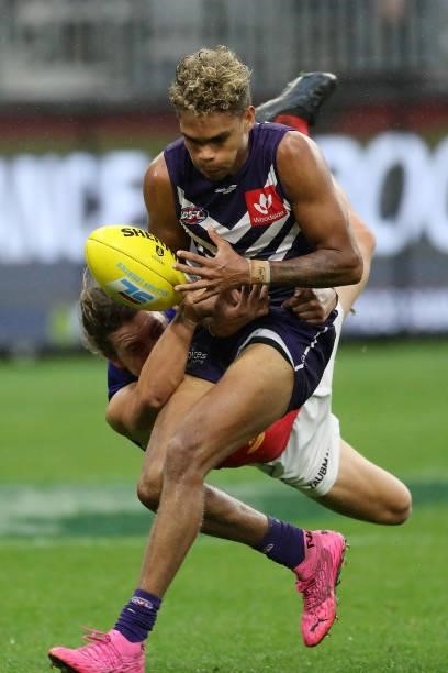 Liam Henry of the Dockers is tackled by Thomas Berry of the Lions during the 2021 AFL Round 21 match between the Fremantle Dockers and the Brisbane...