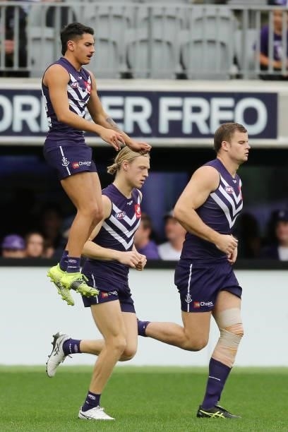 The Dockers run out onto the field during the 2021 AFL Round 21 match between the Fremantle Dockers and the Brisbane Lions at Optus Stadium on August...