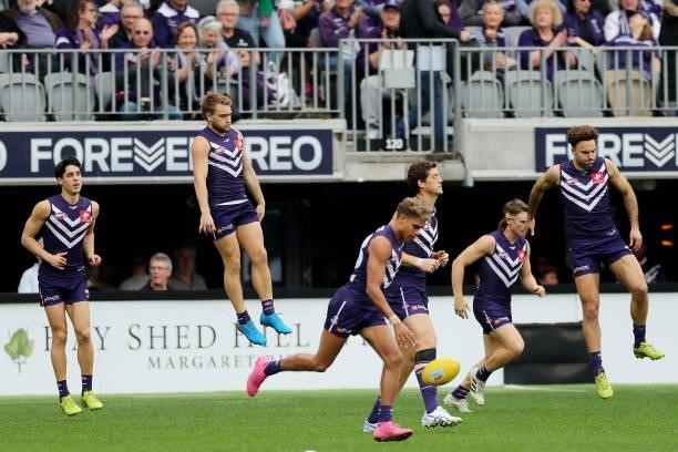 The Dockers run out onto the field during the 2021 AFL Round 21 match between the Fremantle Dockers and the Brisbane Lions at Optus Stadium on August...