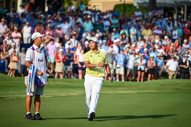 Hideki Matsuyama of Japan and his caddie Shota Hayafuji react to missing a birdie putt on the 18th hole during a playoff in the final round of the...