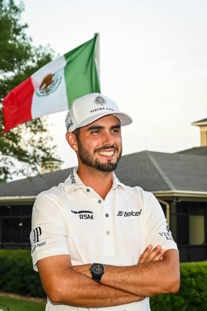 Abraham Ancer of Mexico smiles near the Mexican flag following his playoff victory in the final round of the World Golf Championships-FedEx St. Jude...