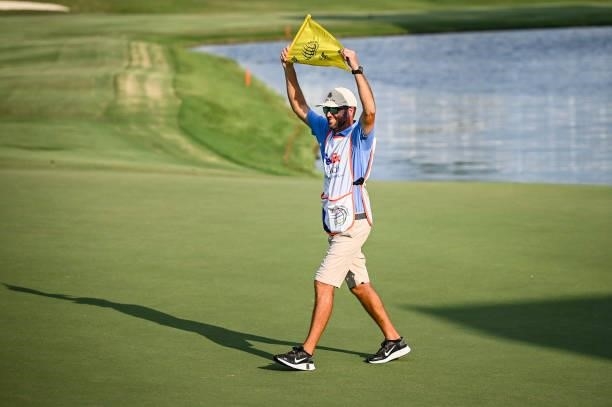 Benji Thompson, caddie for Abraham Ancer of Mexico, smiles with the pin flag on the 18th hole following Ancers playoff victory in the final round of...