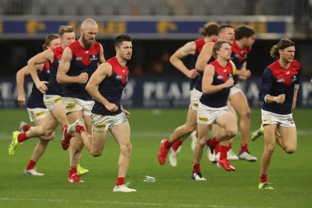 Melbourne players re- enter there field after the delay with the severe weather during the 2021 AFL Round 21 match between the West Coast Eagles and...