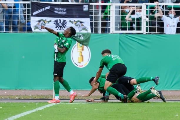 Goalkeeper Niklas Klinger of VfL Wolfsburg celebrates after scoring his team's first goal with teammates during the DFB Cup first round match between...