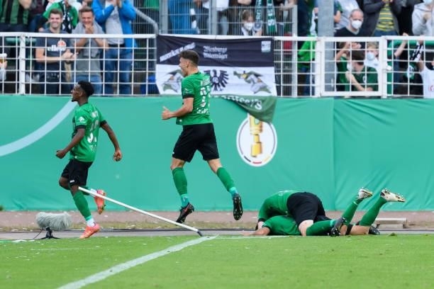 Goalkeeper Niklas Klinger of VfL Wolfsburg celebrates after scoring his team's first goal with teammates during the DFB Cup first round match between...