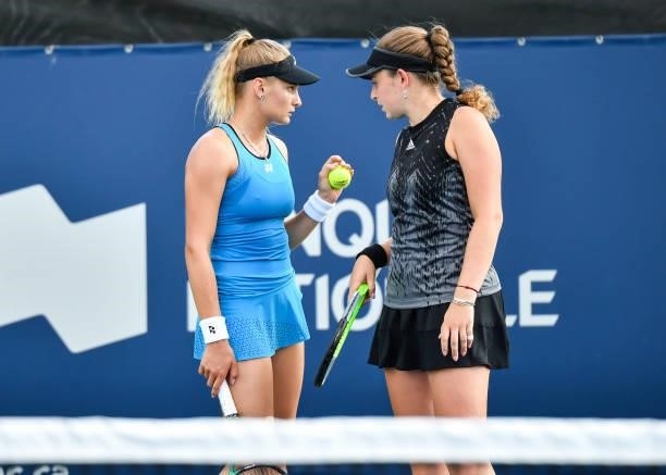 Dayana Yastremska of Ukraine and teammate Jelena Ostapenko of Latvia talk during their Women's Doubles match against Ellen Perez of Australia and...